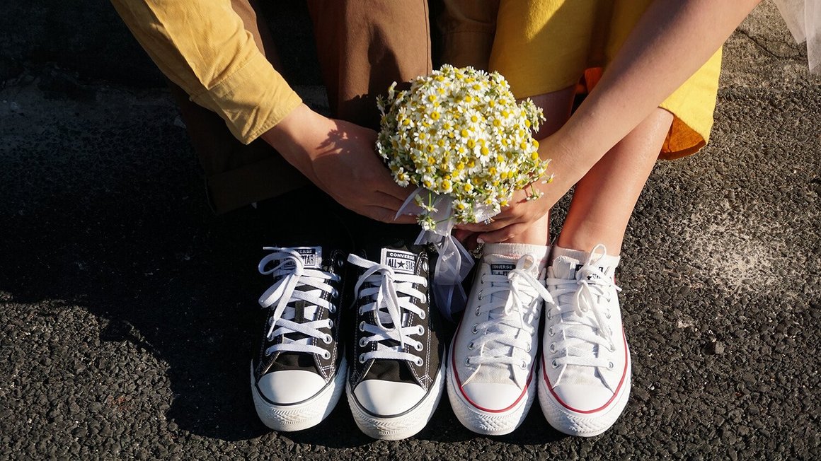 Пара сидить на підлозі з квітами в руках - Планування весілля