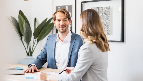 Чоловік і жінка сидять за столом та розмовляють.