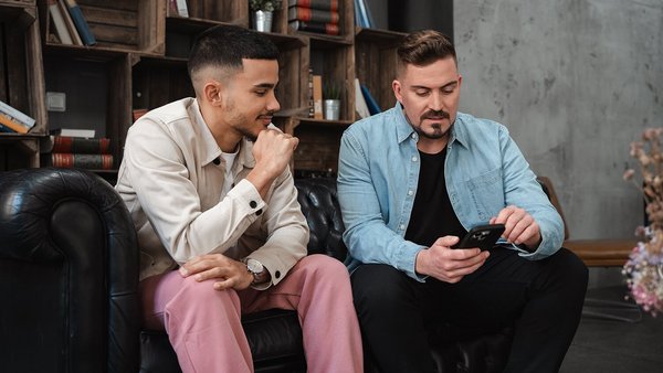 Молоде покоління і пенсія Двоє студентів розмовляють на дивані