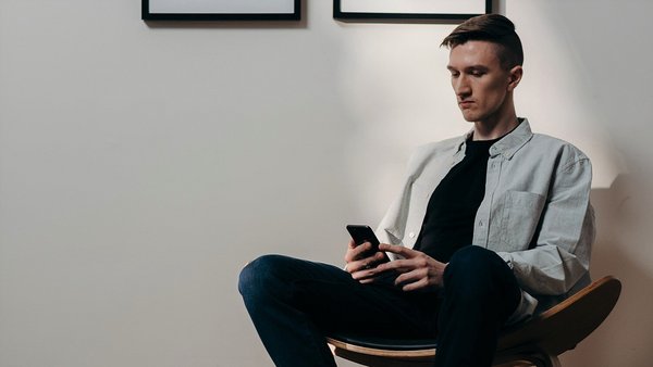 Чоловік з тривогою дивиться у мобільний телефон – зростання цін Чоловік з тривогою дивиться у мобільний телефон – зростання цін