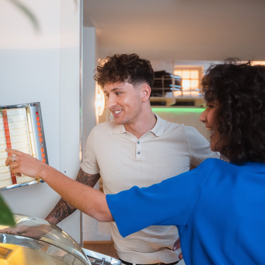 Наші партнери та продукти Чоловік і жінка дивляться на стенд та посміхаються у професійному середовищі.