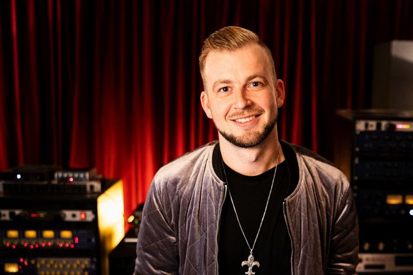 Чоловік посміхається в студії звукозапису.