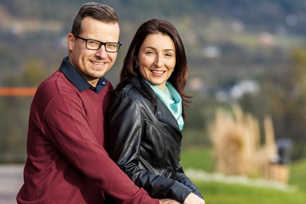 Пара стоїть на вулиці та посміхається.