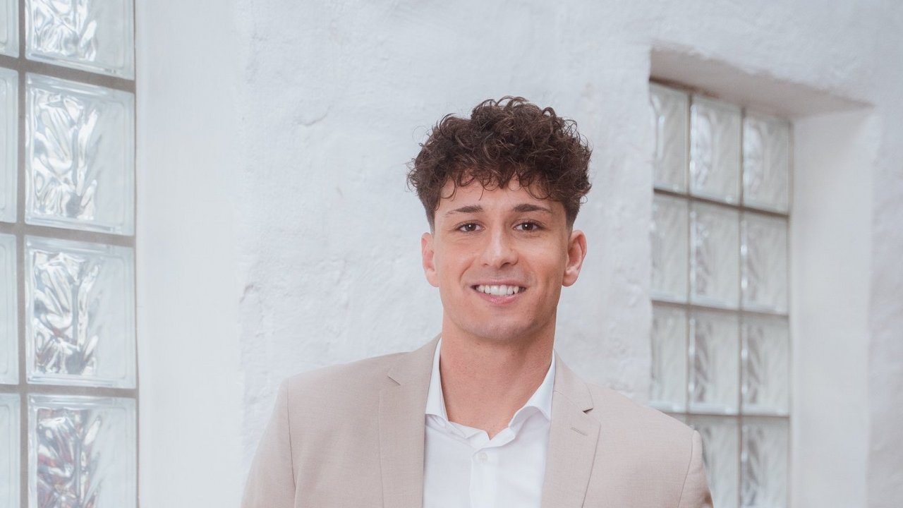 Усміхнений чоловік стоїть в офісі.