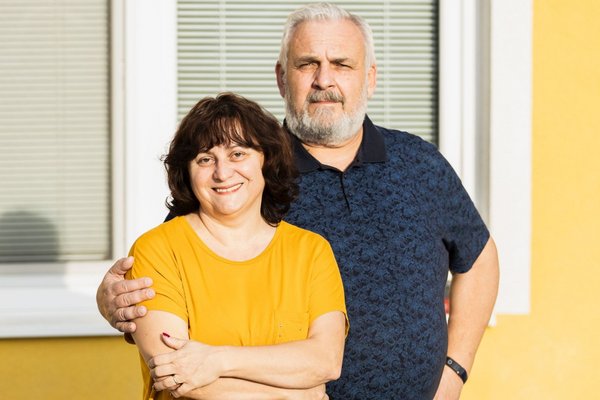 Пара стоїть на вулиці та посміхається.