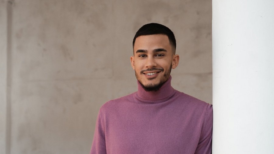 Чоловік стоїть біля стіни