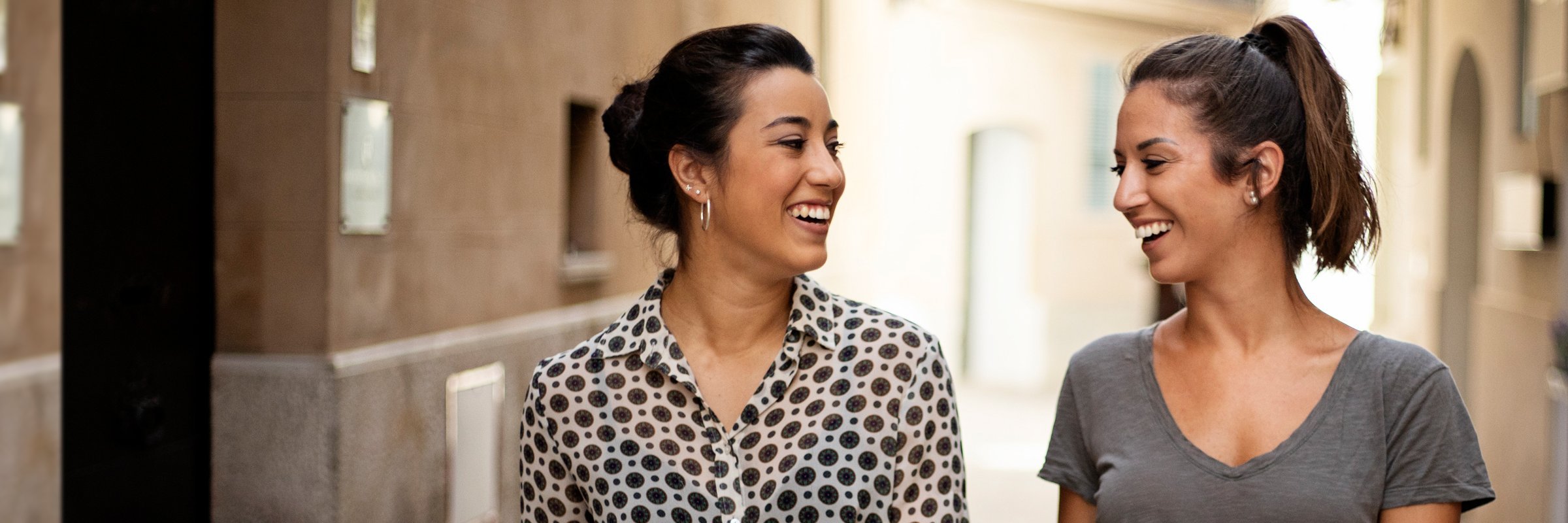 Дві жінки усміхаються на вулиці